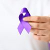 woman,with,purple,ribbon,as,symbol,of,world,cancer,day,