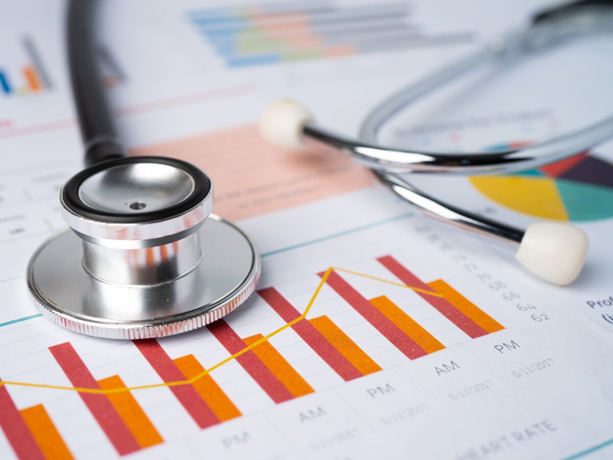 La nouvelle tendance en matière de soins de santé 1 stethoscope on charts and graphs spreadsheet paper, finance, account, statistics, investment, analytic research data economy and business company concept.