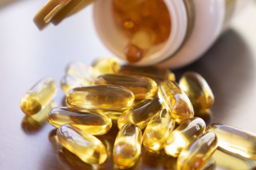 Les compléments alimentaires Memoplex pour l'immunité et la perte de poids 1 fish oil capsules with omega 3 and vitamin d in a glass bottle on wooden texture, healthy diet concept, close up shot.