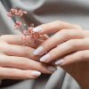 female,hands,with,white,nail,design.,female,hands,holding,pink
