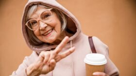 happy elderly woman showing v sign stock photo