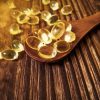 vitamin,d,yellow,pills,on,wood,spoon,on,wooden,background