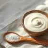 colostrum ou probiotiques : bol de yaourt nature et poudre crème sur une table en bois